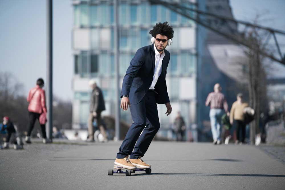 Man in suit riding skateboard